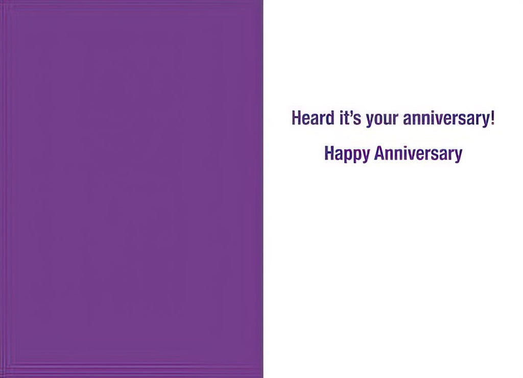 Inside of a humorous anniversary card, with simple text reading 'Heard it's your anniversary! Happy Anniversary' in a purple font on a white background, suitable for celebrating a milestone.