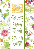 Front of a heartfelt birthday greeting card for a sister, featuring a vibrant watercolor floral border, a green stripe, and script text 'So very happy To call you my sister'.