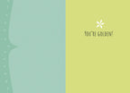 Inside of a friendship greeting card, showing a split design. The left side is a plain pastel blue-green. The right side is a cheerful pastel yellow-green with a small white floral graphic and the bold black text 'YOU'RE GOLDEN!'. This image highlights the encouraging and positive message within the card.