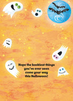 The inside of a whimsical greeting card featuring the message "Hope the kookiest things you've ever seen come your way this Halloween!" surrounded by playful white ghosts and scattered stars on a bright orange background.