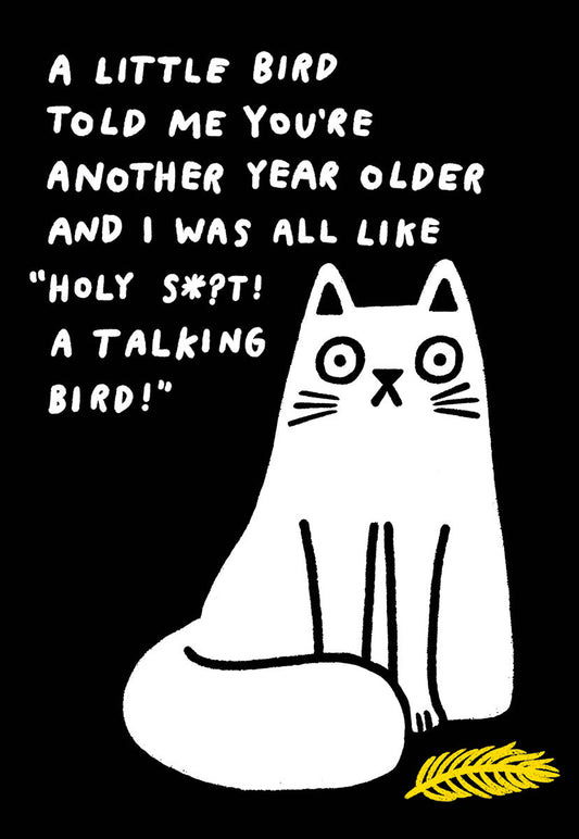 Funny greeting card front features a wide-eyed white cat looking shocked next to a yellow feather. Text: A LITTLE BIRD TOLD ME YOU'RE ANOTHER YEAR OLDER AND I WAS ALL LIKE "HOLY S*?T! A TALKING BIRD!"