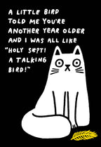 Humorous greeting card with a surprised white cartoon cat on a black background, alongside the witty text 'A little bird told me you're another year older and I was all like "Holy S*!t! A talking bird!"'. Features a small yellow feather.