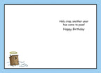 Inside of a funny birthday card, showing the message 'Holy crap, another year has come to pass! Happy Birthday' in black text on a light blue background, with a small outhouse icon adorned with a halo in the bottom left corner.