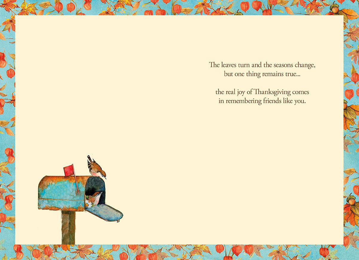 Inside view of a heartfelt Thanksgiving greeting card with a cream background and a decorative border of autumn leaves and Chinese lanterns. The message reads: 'The leaves turn and the seasons change, but one thing remains true... the real joy of Thanksgiving comes in remembering friends like you.' A small bird and mailbox illustration appears at the bottom left.