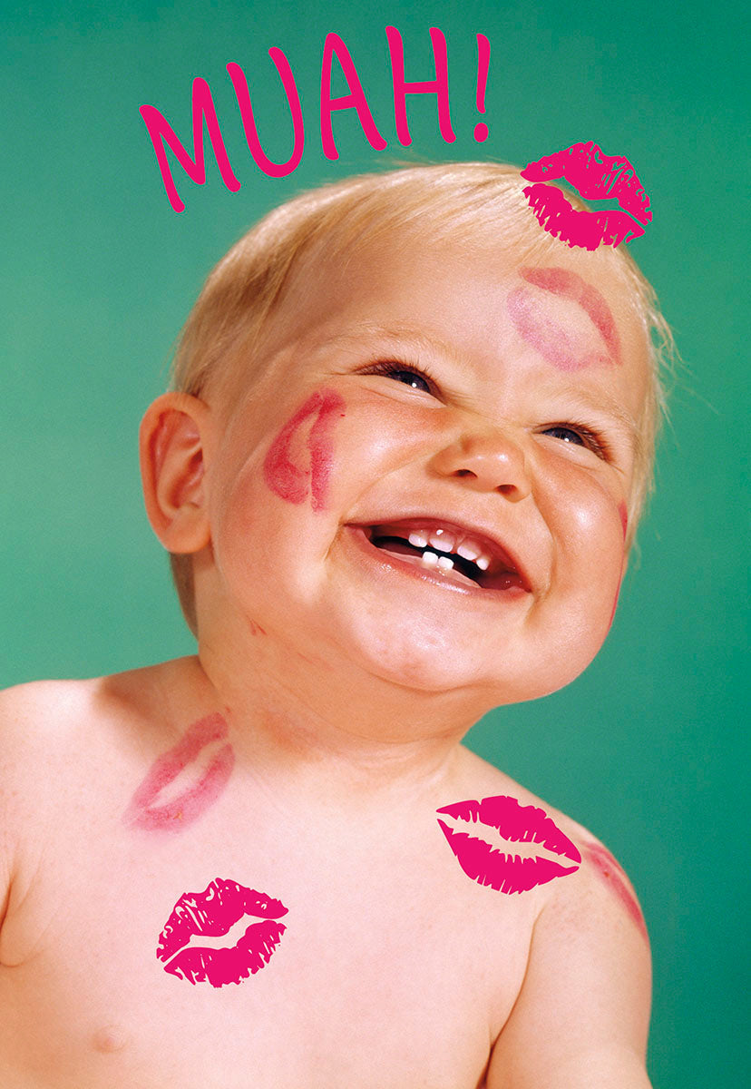 Joyful baby with multiple pink lipstick kisses on their cheeks, forehead, and shoulder, smiling broadly against a vibrant teal background. The word 'MUAH!' in pink capital letters is above their head, perfect for a cute Valentine's Day greeting card for a child.