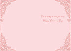 Inside view of a romantic Valentine's Day greeting card with a light pink background and delicate red ornate borders in each corner, featuring elegant red script text that reads 'I'm so lucky to call you mine. Happy Valentine's Day'.