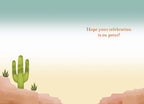 Inside of a lighthearted greeting card with a simple desert landscape, a small cactus, and text 'Hope your celebration is on point!'.