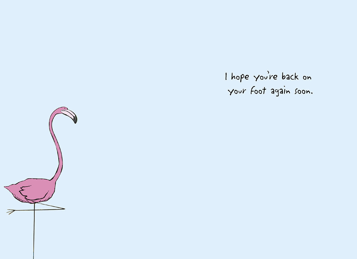 Inside of a humorous flamingo greeting card with one pink flamingo standing and the text 'I hope you're back on your foot again soon' for a speedy recovery message.