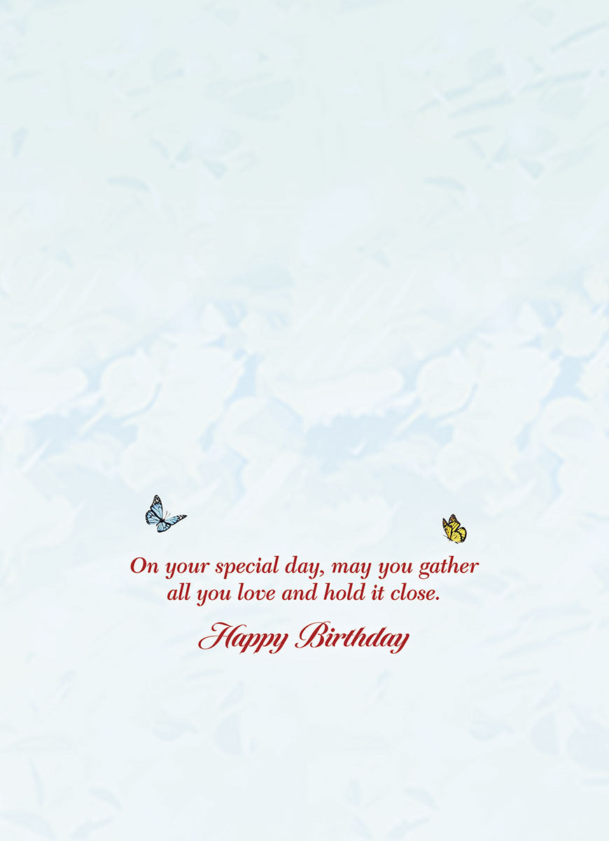 Inside of a heartfelt birthday greeting card with a thoughtful message in elegant red script: 'On your special day, may you gather all you love and hold it close. Happy Birthday.' Accented by small blue and yellow butterflies.