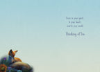 Inside of a 'Thinking of You' greeting card with a soft blue gradient background. Text reads: 'Peace to your spirit... to your heart... and to your world. Thinking of You.' A small sleeping fox and flowers are visible in the bottom left corner.