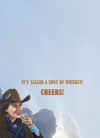 Inside view of a humorous adult greeting card revealing the punchline 'IT'S CALLED A SHOT OF WHISKEY! CHEERS!' with a winking cowgirl, perfect for liquor lovers.