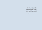 Inside of a humorous greeting card with a light blue background, displaying the text 'You're pretty and you need more wine... now say it back to me!'