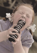 Close-up of a joyful child with pigtails excitedly eating a tall stack of chocolate cream cookies, capturing a moment of pure sugary delight. Perfect for a kids' special day card.
