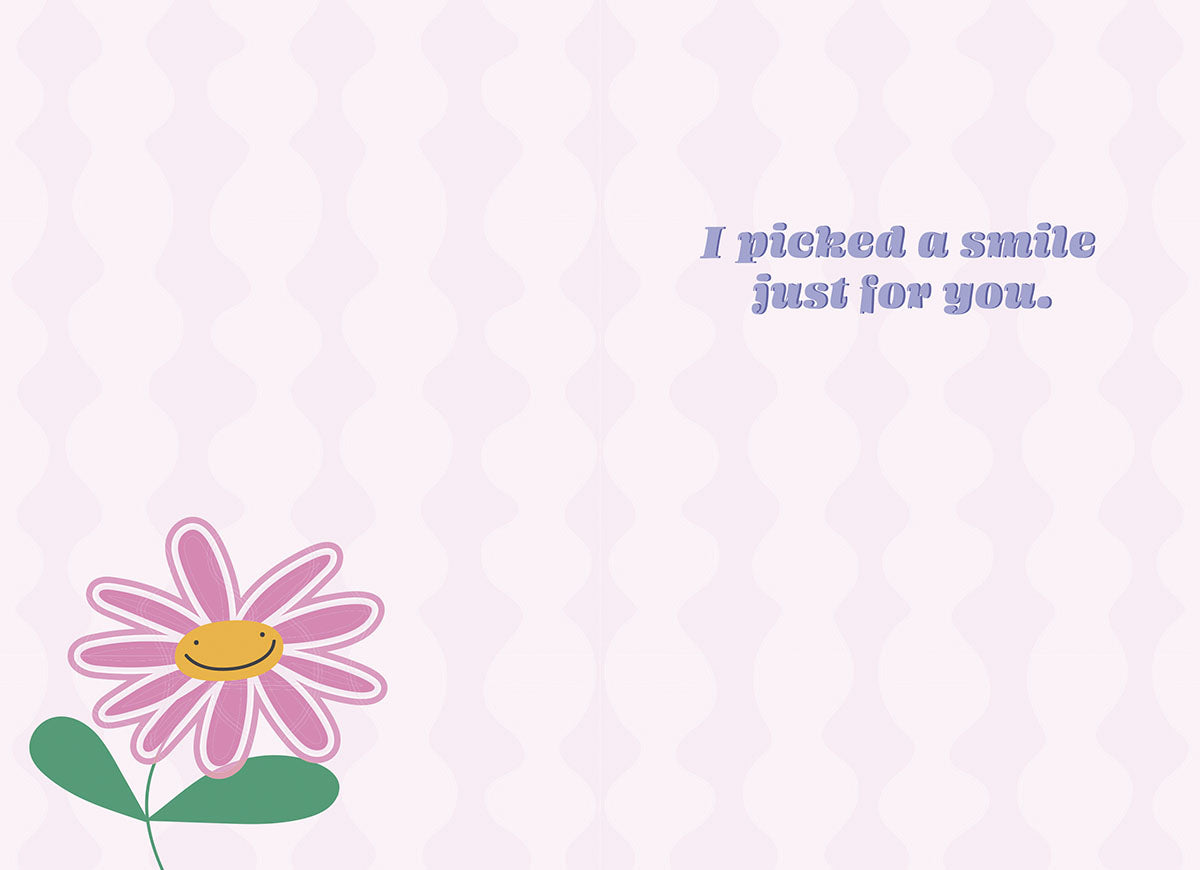 Inside view of a friendship greeting card featuring a small pink smiley face flower illustration and the warm message 'I picked a smile just for you.' on a soft lavender patterned background.