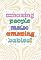 Greeting card front with the phrase 'amazing people make amazing babies!' in colorful, stacked block letters on a cloud design with sparkling gold stars and a sunburst background, celebrating a new arrival.