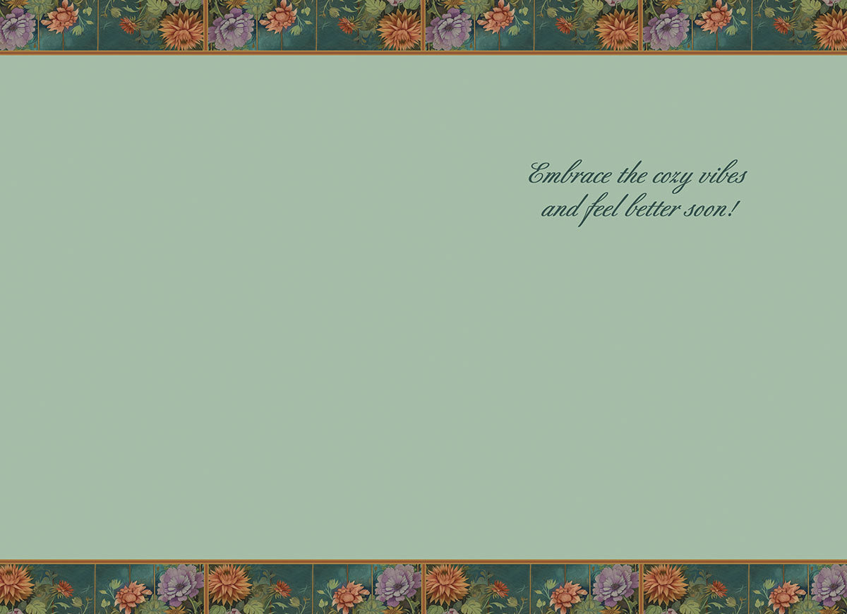 Inside of a 'Get Well' card for children, displaying a soft light green background. The top and bottom borders feature intricate floral patterns matching the card's front design. The elegant script reads: 'Embrace the cozy vibes and feel better soon!', providing a heartfelt message for a speedy recovery.