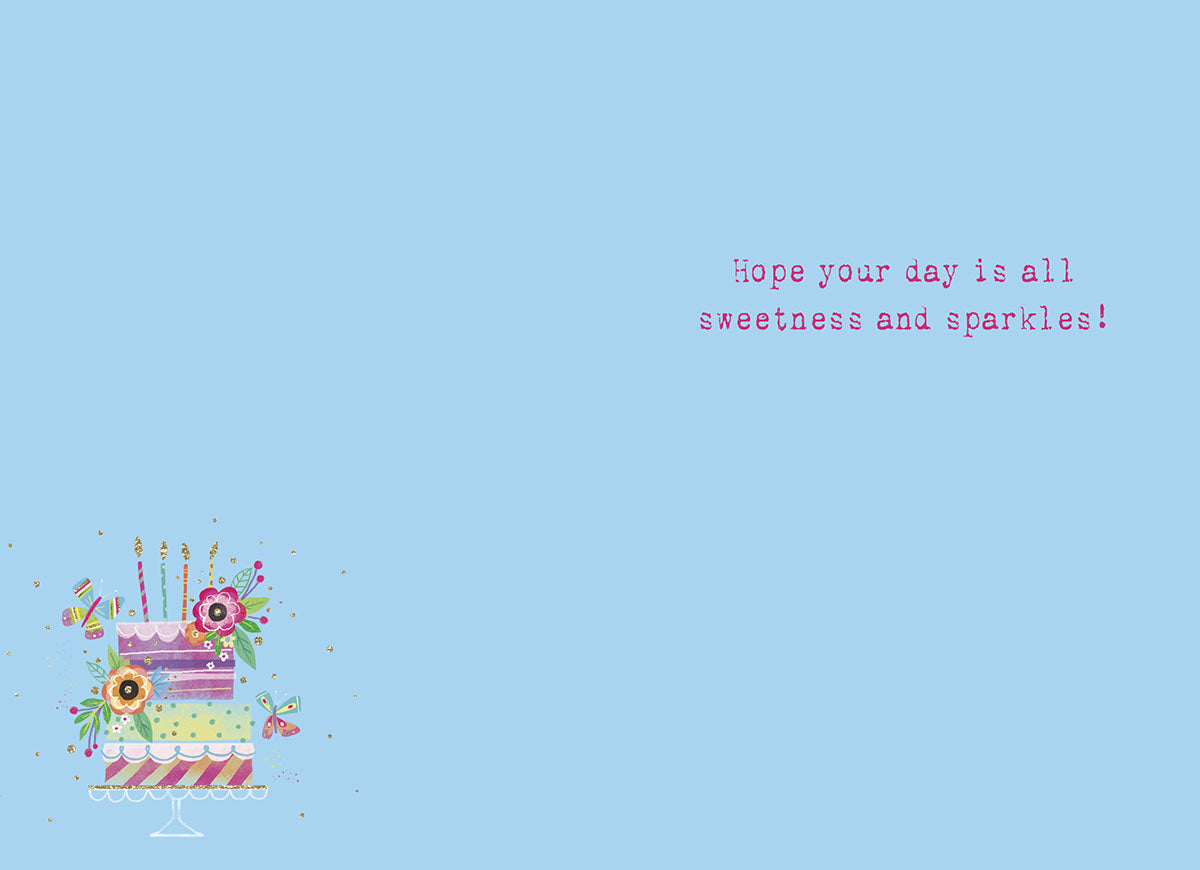 Open birthday greeting card with a light blue interior, featuring a small matching tiered cake design and the sweet message: 'Hope your day is all sweetness and sparkles!'
