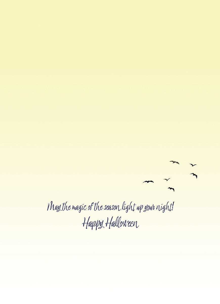 Inside of a cute Halloween card with a warm, gradient yellow background and elegant script that reads 'May the magic of the season light up your night! Happy Halloween.' Small flying birds adorn the bottom right.