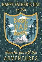 Father's Day greeting card with 'Best Dad Ever' in a shield design featuring mountains, pine trees, and clouds, on a dark green background with small tree patterns. Text reads: 'Happy Father's Day to the Best Dad Ever thanks for all the adventures.'