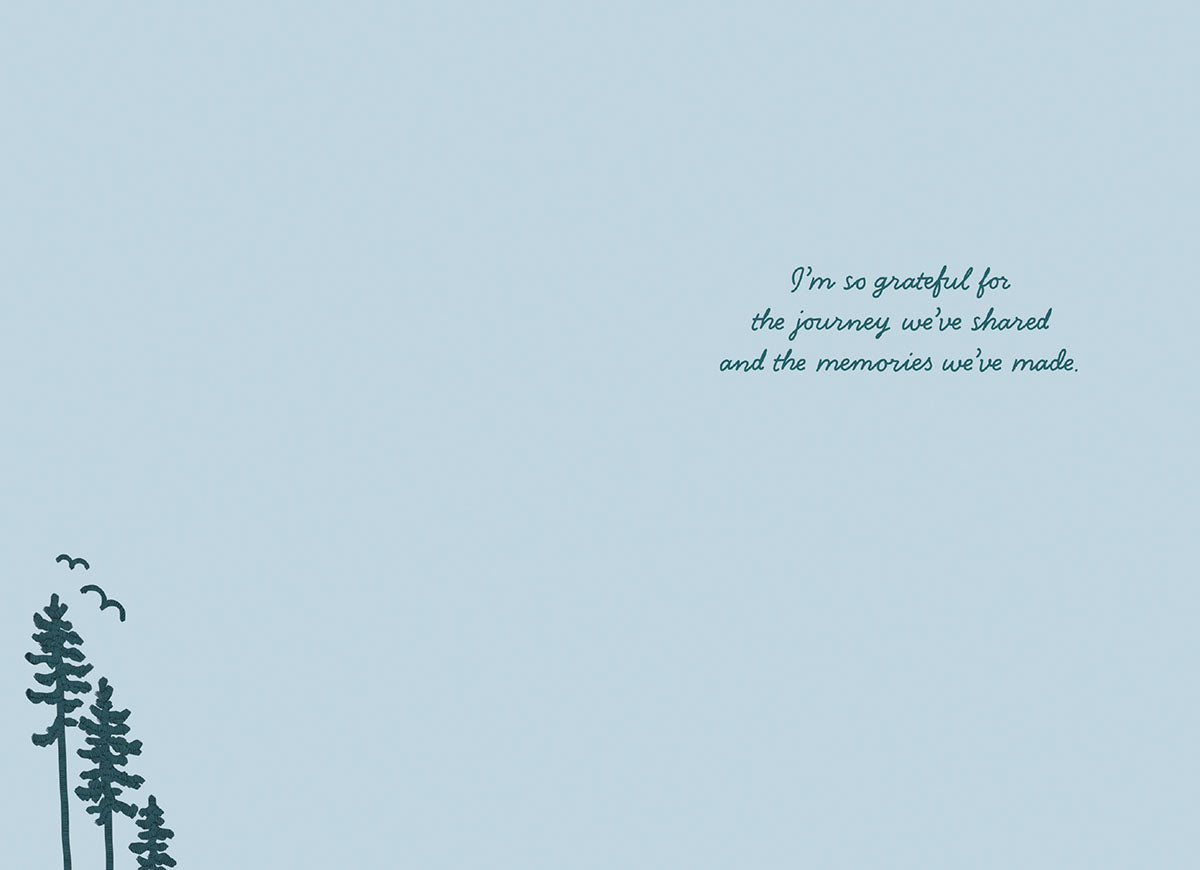 Inside of a Father's Day greeting card on a light blue background with 'I'm so grateful for the journey we've shared and the memories we've made' text and subtle pine tree illustrations in the bottom left.