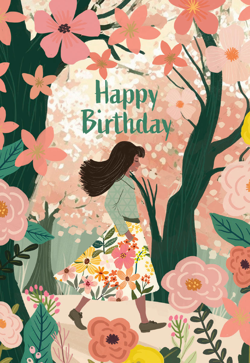 Front of a Mia Charro 'Happy Birthday' card, showing a woman walking through a lush floral forest.
