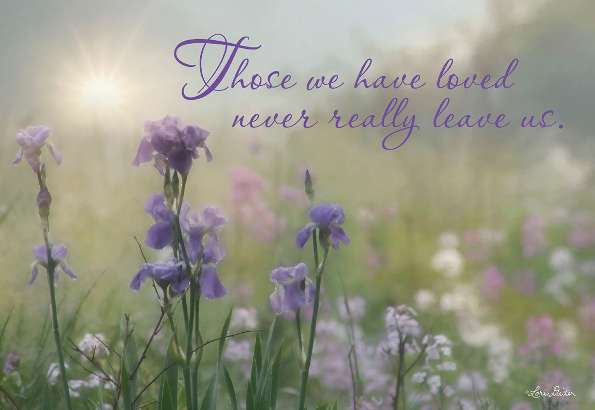 Front of a comforting sympathy greeting card featuring soft purple irises in a field with a gentle sunbeam, conveying a heartfelt message: 'Those we have loved never really leave us.' Perfect for offering condolences and support during loss.