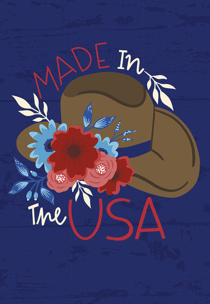 Front of a greeting card with a cowboy hat adorned with red and blue flowers, text "Made In The USA" on blue wood.