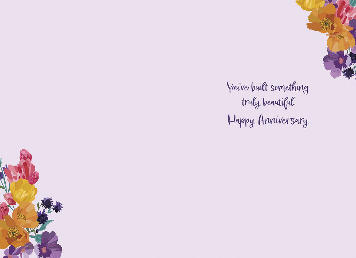 Inside of the "Lucky in Love" card, with floral corners, text: "You've built something truly beautiful. Happy Anniversary".