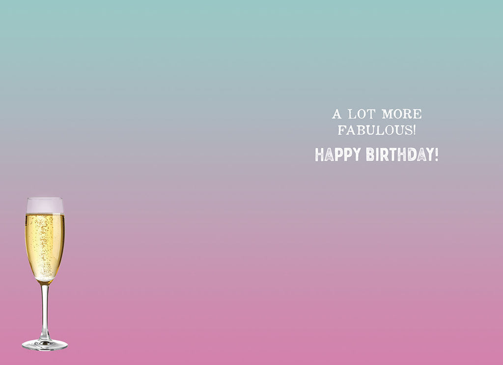 Inside of a lighthearted greeting card featuring a single champagne flute on a pink to blue gradient background, with the festive message 'A LOT MORE FABULOUS! HAPPY BIRTHDAY!'.