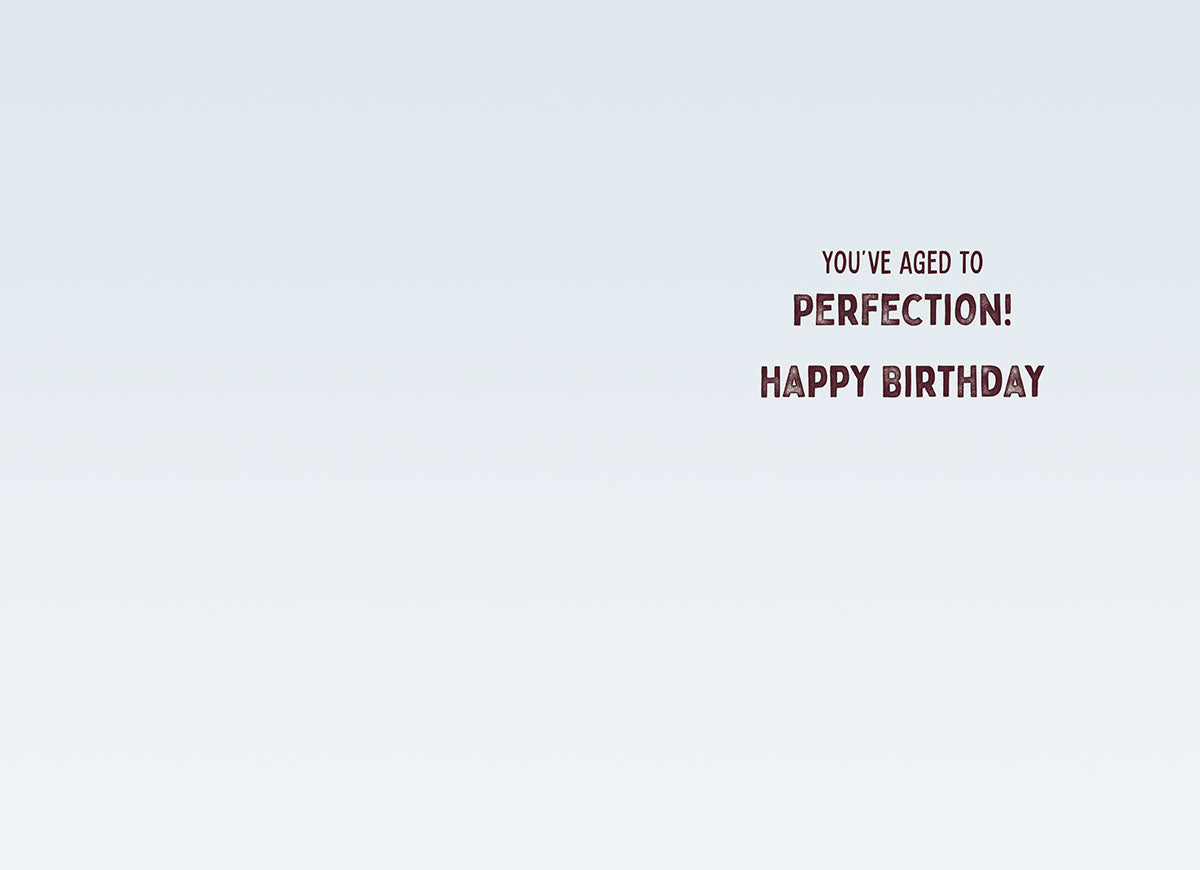 Inside of a funny adult birthday greeting card showing a clean, light blue background with the celebratory message 'YOU'VE AGED TO PERFECTION! HAPPY BIRTHDAY' in a stylish font.