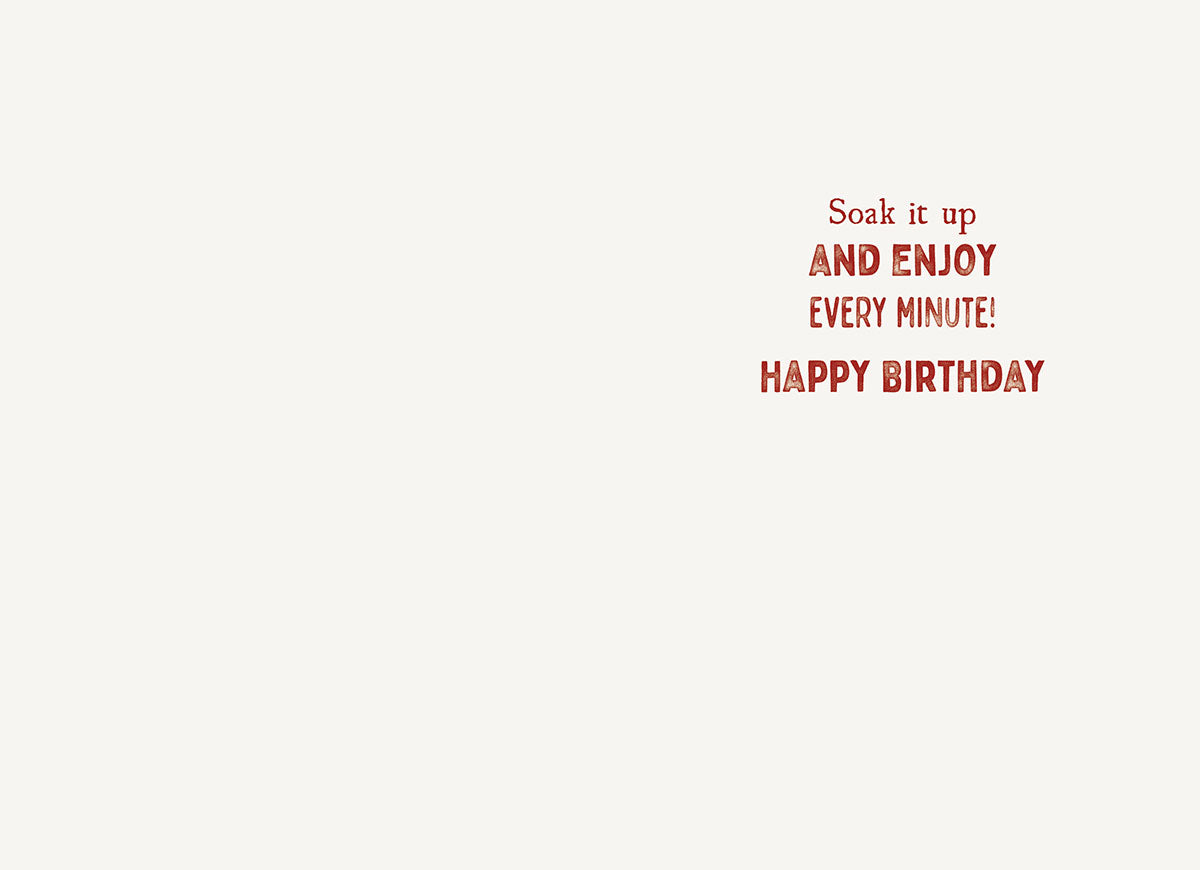 Inside of a greeting card with a simple white background and red text that reads: 'Soak it up AND ENJOY EVERY MINUTE! HAPPY BIRTHDAY'.