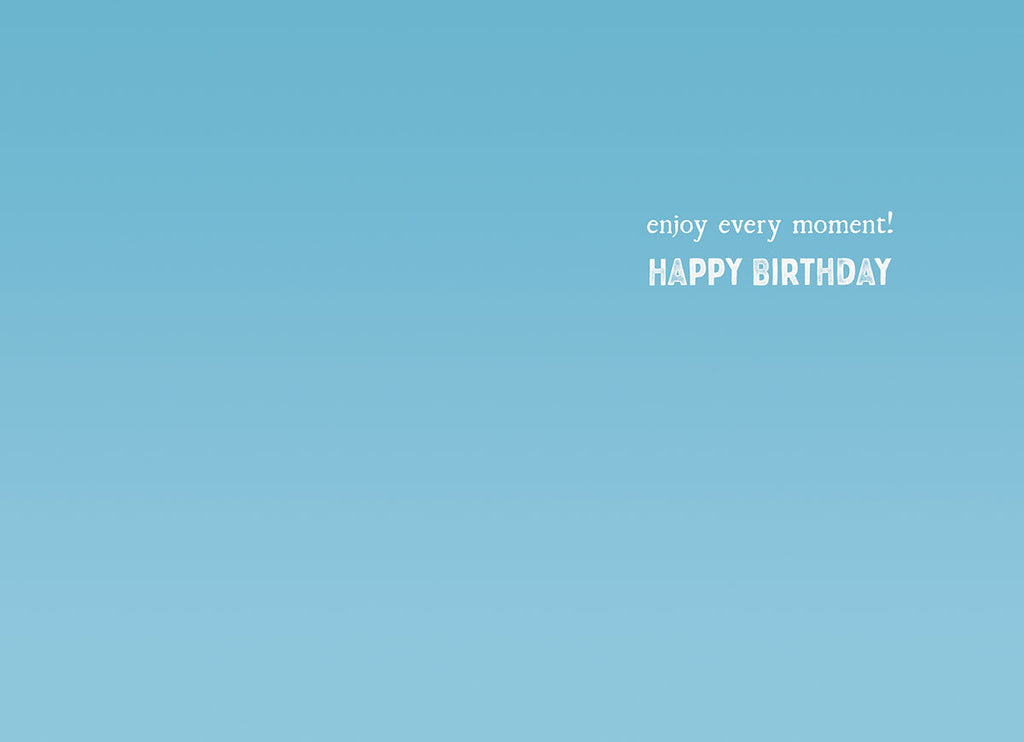 Inside view of a light blue birthday greeting card with white text that reads 'enjoy every moment! HAPPY BIRTHDAY', offering a heartfelt message.
