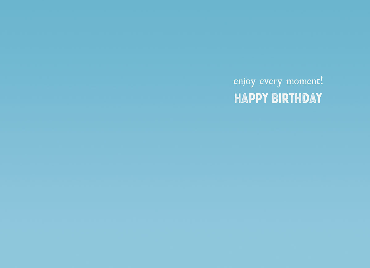 Inside view of a light blue birthday greeting card with white text that reads 'enjoy every moment! HAPPY BIRTHDAY', offering a heartfelt message.