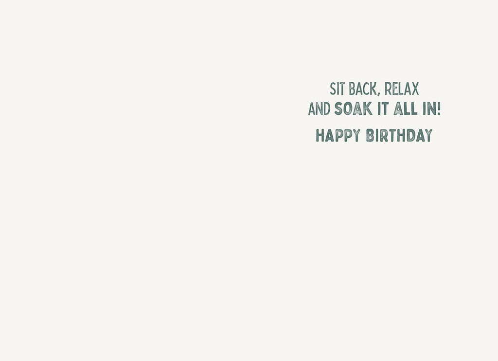 Inside view of a lighthearted celebration card, showing a simple and cheerful message printed in dark grey text on a white background: 'SIT BACK, RELAX AND SOAK IT ALL IN! HAPPY BIRTHDAY'.