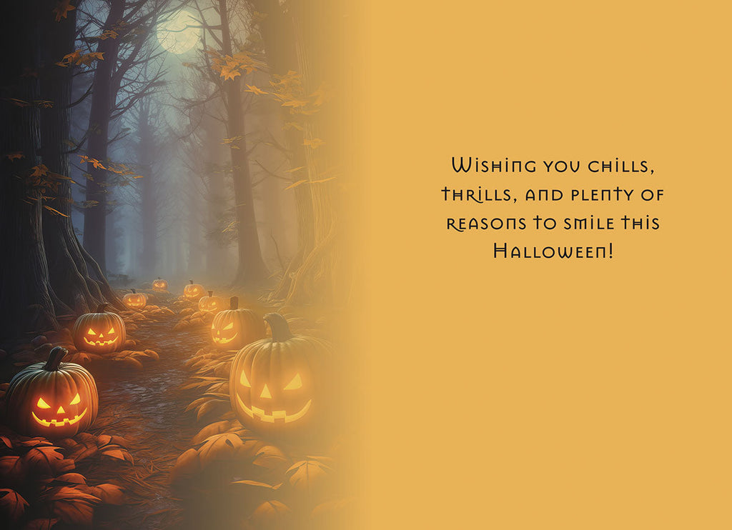 Inside of a themed greeting card featuring a mysterious forest path lined with glowing jack-o-lanterns and the message: 'Wishing you chills, thrills, and plenty of reasons to smile this Halloween!'