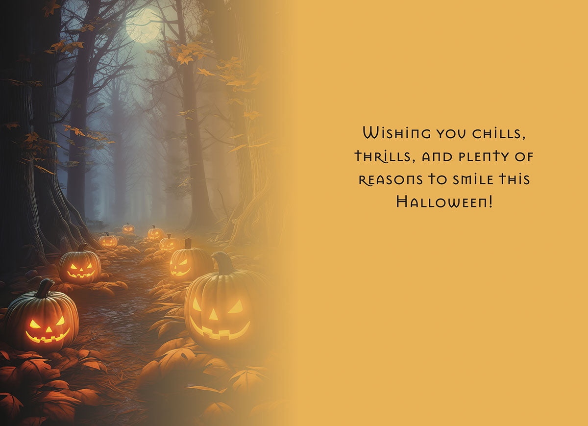 Inside of a themed greeting card featuring a mysterious forest path lined with glowing jack-o-lanterns and the message: 'Wishing you chills, thrills, and plenty of reasons to smile this Halloween!'