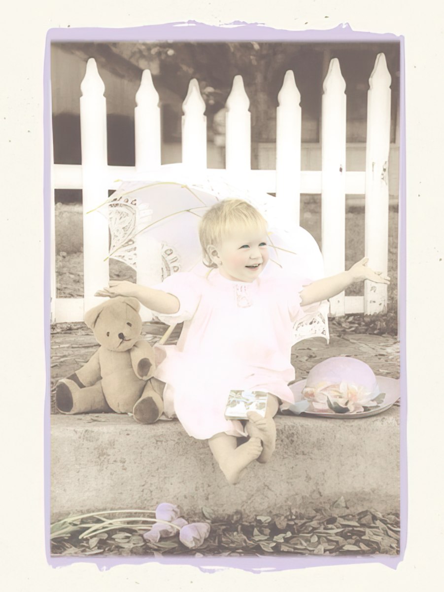 Greeting card front showing a happy little girl in pink with a teddy bear by a white picket fence.