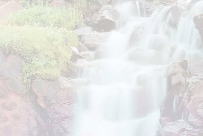 Soft focus, light version of the waterfall cascading over rocks.