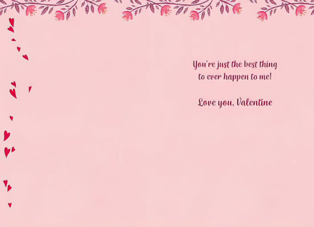 Inside view of an open Valentine's Day card, displaying a heartfelt message 'You're just the best thing to ever happen to me! Love you, Valentine' on a light pink page with subtle floral and heart accents.