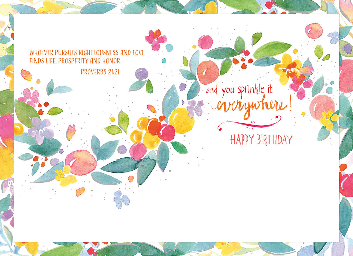 Open religious greeting card interior with Proverbs 21:21 and 'and you sprinkle it everywhere! HAPPY BIRTHDAY' surrounded by colorful watercolor flowers and foliage.
