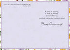 Inside of a religious anniversary card displaying Bible verse Matthew 21:42 and a heartfelt message 'A year of growing, a year of sharing, a year of loving... Just look what the Lord has done! Happy Anniversary' with watercolor floral border.