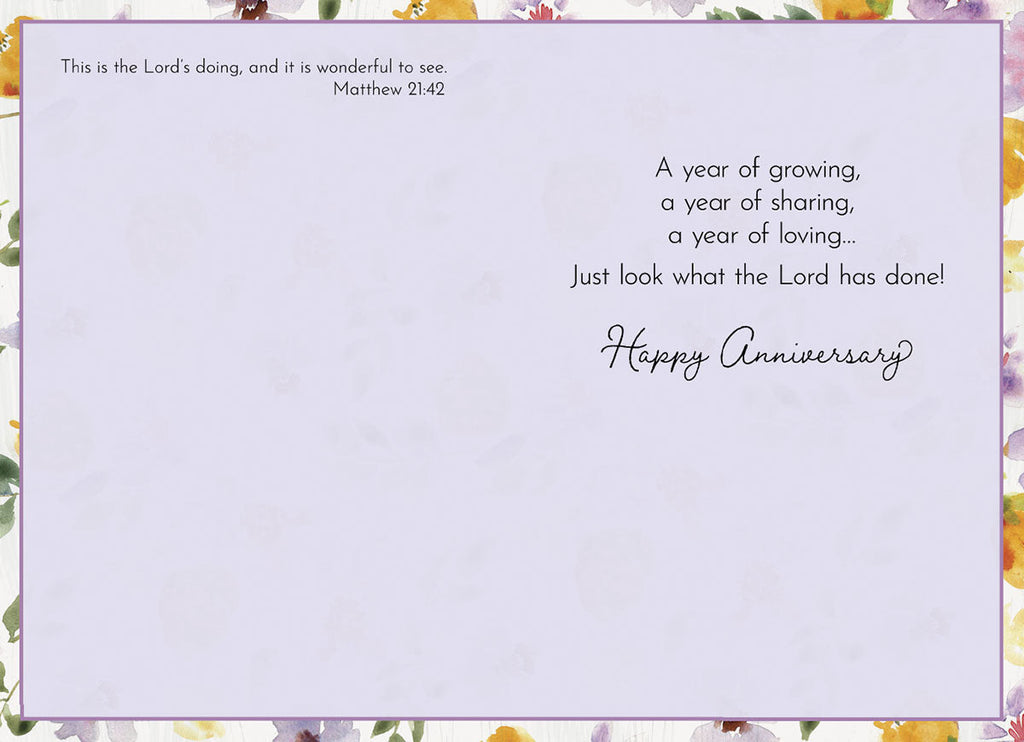 Inside of a religious anniversary card displaying Bible verse Matthew 21:42 and a heartfelt message 'A year of growing, a year of sharing, a year of loving... Just look what the Lord has done! Happy Anniversary' with watercolor floral border.