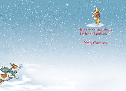 Inside of a Christmas greeting card with a small dog jumping for a snowflake and the message: 'Hope every single minute has fun and smiles in it! Merry Christmas'.