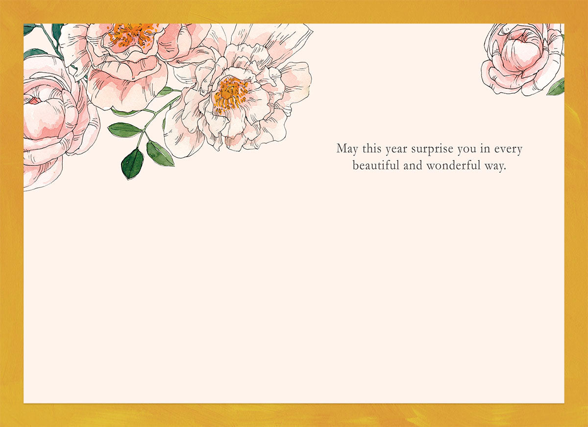 Inside view of the Bloom Wishes birthday card, showing the blank space for a personalized message, decorated with delicate pink watercolor flowers and a pre-printed heartfelt wish: 'May this year surprise you in every beautiful and wonderful way.'