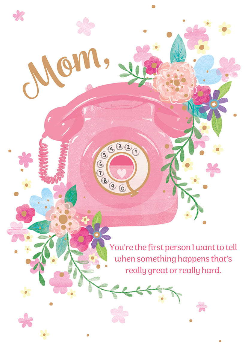 Front of a Mother's Day greeting card featuring a pink vintage rotary telephone, surrounded by colorful watercolor flowers in pink, blue, purple, and yellow. The text "Mom," is written above the phone, and below it reads: "You're the first person I want to tell when something happens that's really great or really hard."