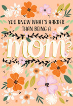 Illustrated Mother's Day greeting card front with vibrant orange, white, and purple flowers and bold text 'YOU KNOW WHAT'S HARDER THAN BEING A MOM?' on a peach background, perfect for showing appreciation to her.