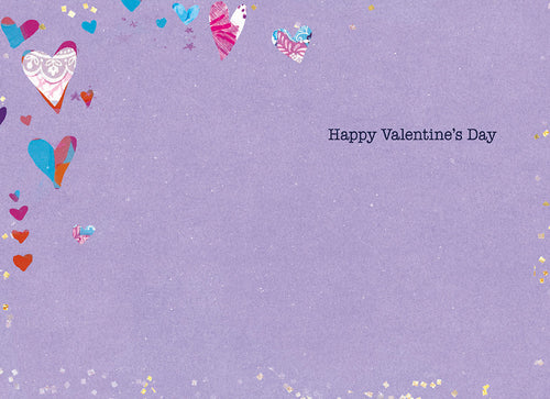 Inside of a thoughtful greeting card with a soft lavender background, adorned with a scattering of small, colorful collage hearts along the top left and bottom edges. The message 'Happy Valentine's Day' is printed in black text on the right side, offering space for a personalized message.