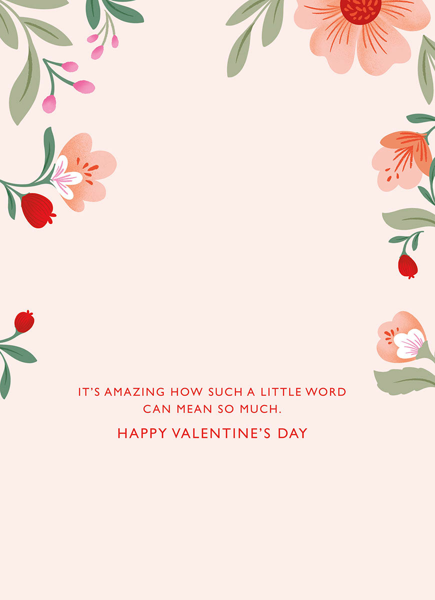 Open romantic greeting card interior with a pastel pink background, elegant floral border design, and heartfelt red text reading 'IT'S AMAZING HOW SUCH A LITTLE WORD CAN MEAN SO MUCH. HAPPY VALENTINE'S DAY' for your spouse.