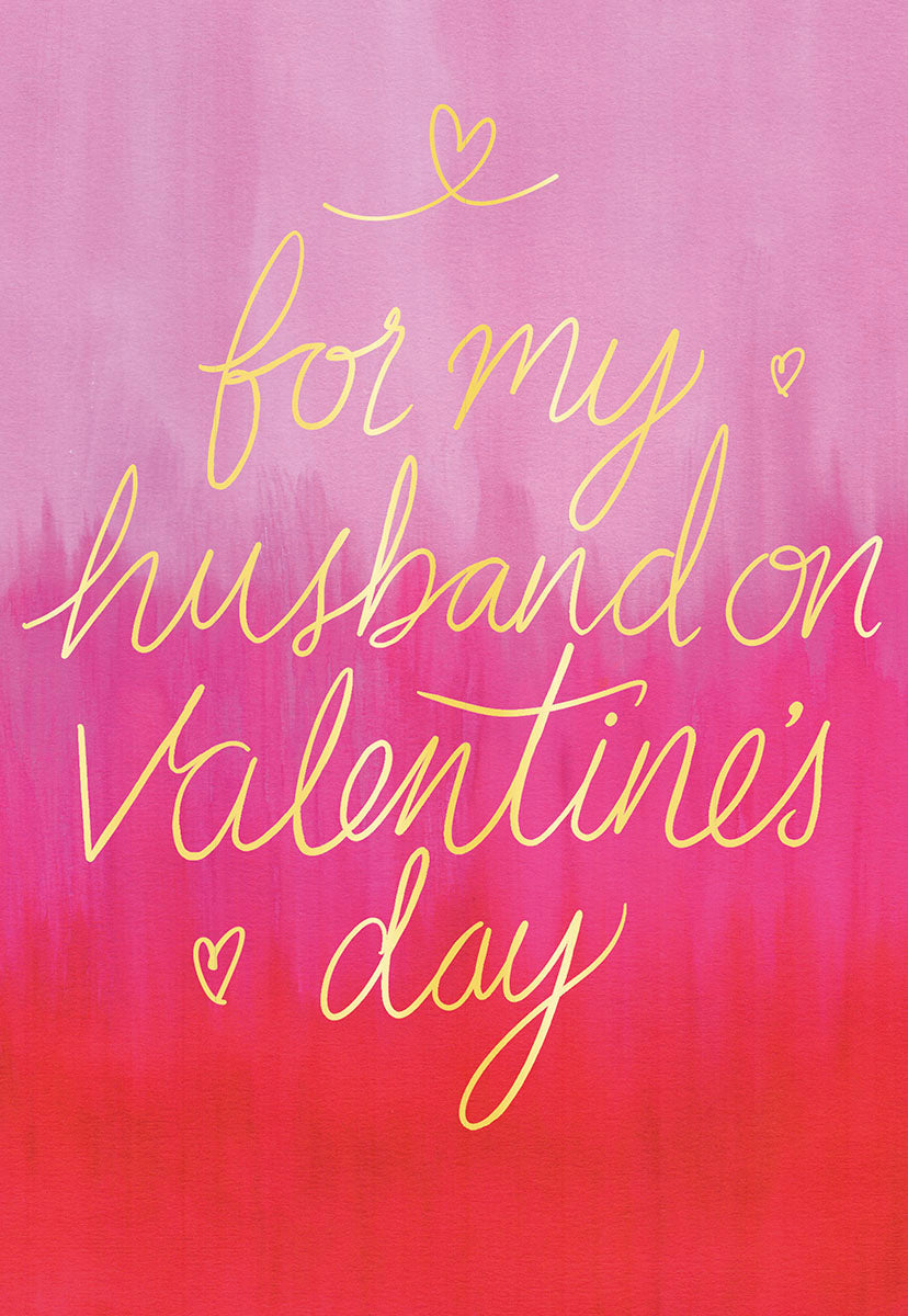 Front of a Valentine's Day greeting card for a husband, featuring gold foil calligraphy saying 'for my husband on Valentine's Day' against a vibrant pink to red gradient background with small heart accents.