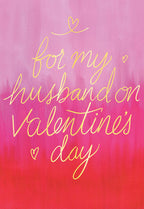 Front of a Valentine's Day greeting card for a husband, featuring gold foil calligraphy saying 'for my husband on Valentine's Day' against a vibrant pink to red gradient background with small heart accents.